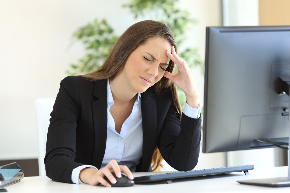 Worried looking business woman at work using a desktop computer in the office