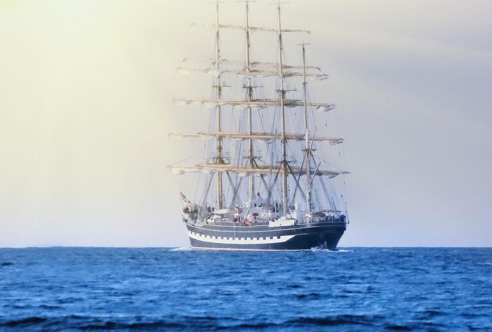 a tall ship is sailing in open waters